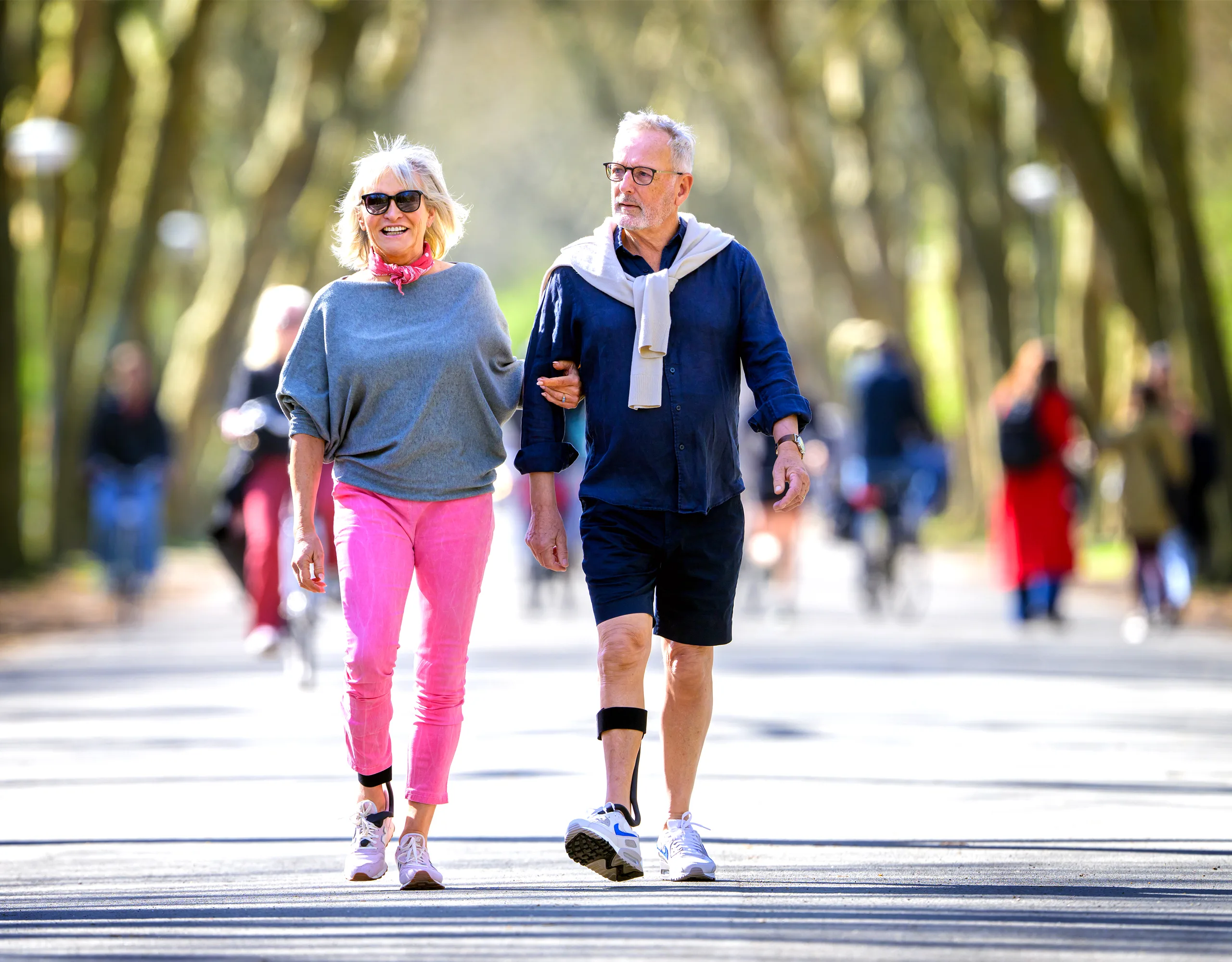 Een stel dat arm in arm door een park wandelt, de man draagt de Rise — de mensen voor wie we bouwen